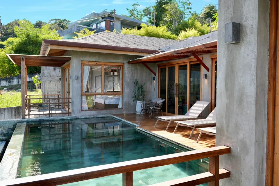 The pool, timber decks and villa rooflines