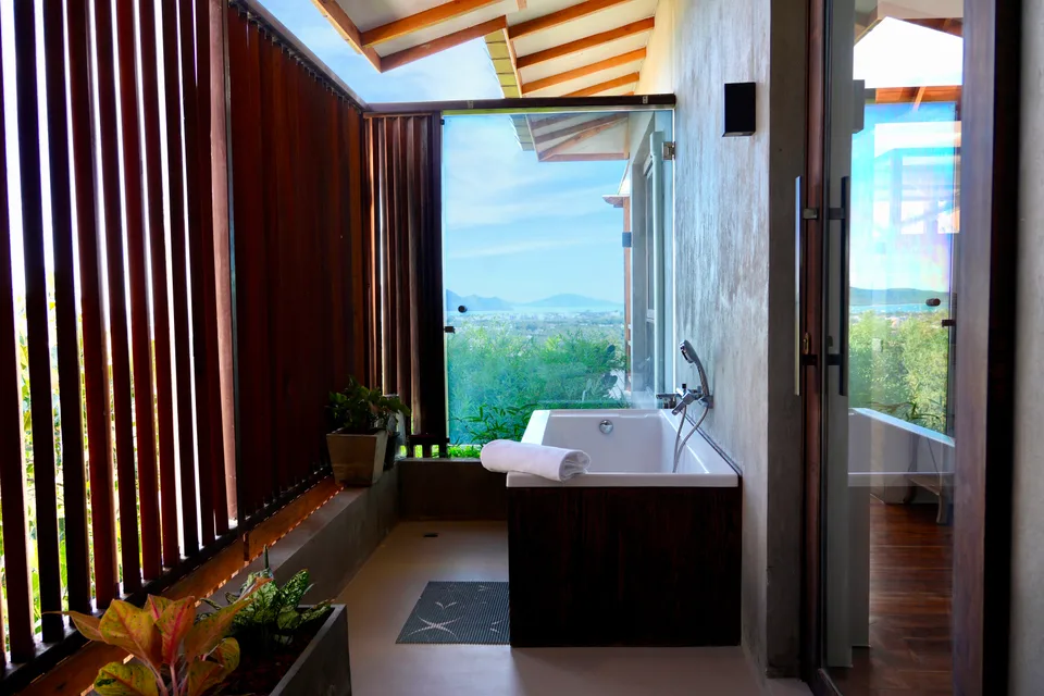 An open-air bathtub and hillside view